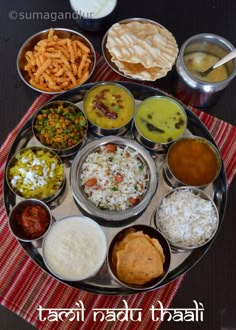 a plate full of different types of food on a red and white table cloth with the words tasty radt thaali