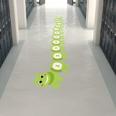 the hallway is lined with lockers and there are green frog decals on the floor