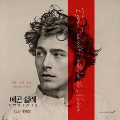 a man with curly hair standing in front of a red and white striped poster