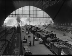 an old black and white photo of trains at a train station