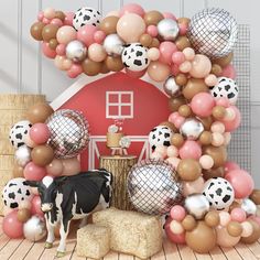 a cow is standing in front of a bunch of balloons and other decorations on the floor