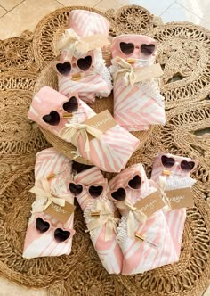 pink and white baby shower favors on a wicker tray with tags that read, towel favors