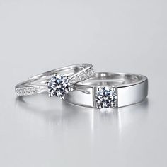 two white gold wedding rings with diamonds on each one and the other side, sitting next to each other