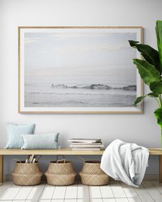 a white room with some plants and baskets on the floor