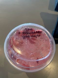 a plastic cup filled with pink liquid and writing on the lid that says i have a strawberry good day