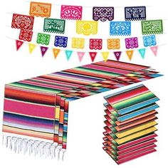 a table covered in lots of different colored paper flags and tassels hanging from it's sides