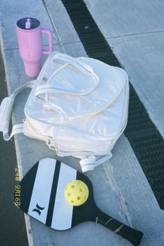 a white bag sitting on the sidewalk next to a paddle