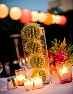 a table with candles and cactus plants on it