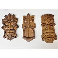 three carved wooden masks sitting next to each other