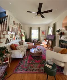 a living room filled with lots of furniture and pictures on the wall next to a fire place