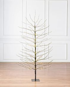 a small white christmas tree sitting on top of a wooden floor