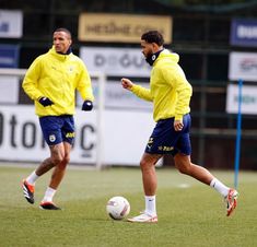 two men in yellow jackets are playing soccer