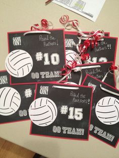 four volleyball signs with ribbons tied around them on a table next to candy canes