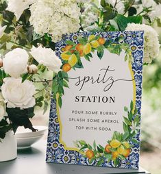 there is a sign on the table with some flowers in front of it that says spity station