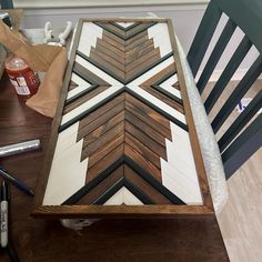 a wooden table topped with lots of different types of paint and woodworking tools on top of it