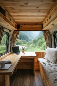 the interior of a camper with a desk and laptop on it's side