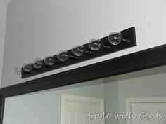 a bathroom mirror with five wine glasses on the top and one in the bottom half