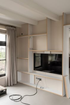 an entertainment center in a living room with built - in shelving and a flat screen tv