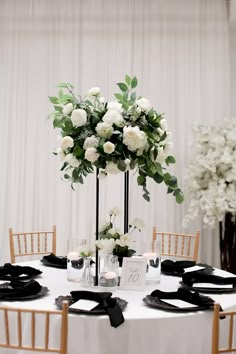 a table with white flowers and black napkins