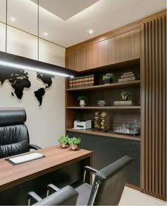 an office with a wooden desk and black leather chairs, along with a map on the wall