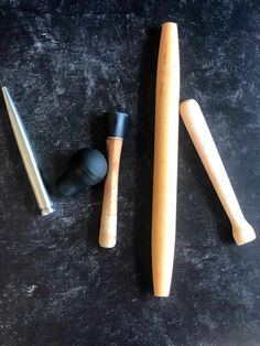 three different types of baseball bats on a black surface with one bat in the middle