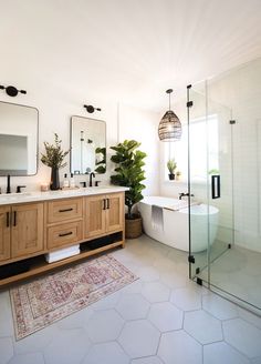 a bathroom with two sinks, a tub and a mirror on the wall next to it