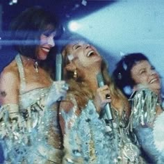 three women in sequins are laughing together