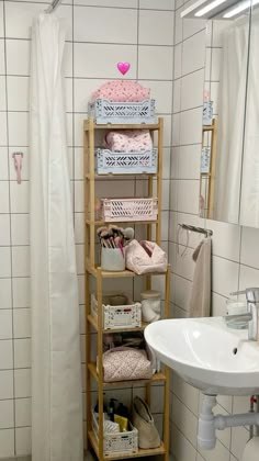 a bathroom with a sink and shelving unit in the corner, next to a shower curtain