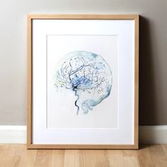 a watercolor painting of a brain in a wooden frame on the floor next to a wall