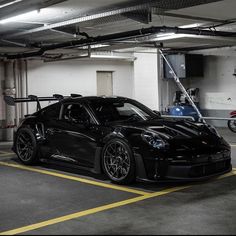 a black sports car parked in a parking garage