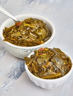 two white bowls filled with food on top of a table