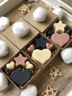 three boxes filled with different shaped cookies on top of a wooden table