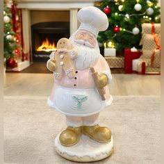 a santa clause figurine holding a teddy bear in front of a christmas tree