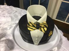 a black and white cake with a gold bow tie on it's lapel