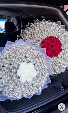 two paper flowers in the back of a car with red and white roses on it