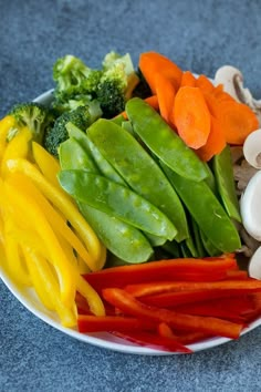 a white plate topped with different types of veggies on top of a table