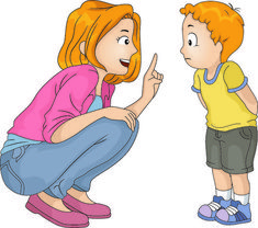 a woman kneeling down next to a little boy who is pointing at him with his finger