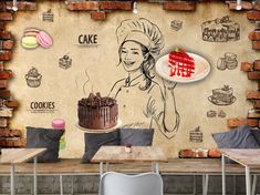 a woman holding a cake in front of a wall mural