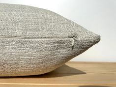 a close up of a pillow on a wooden surface