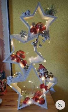 a christmas tree with ornaments and lights on it's sides in the shape of a star