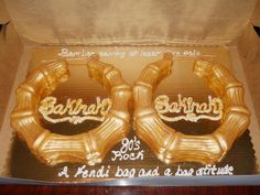 two golden balloons in a box with writing on them