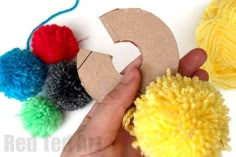 someone is making a craft with pom - poms and cardboard letters that spell out the letter c