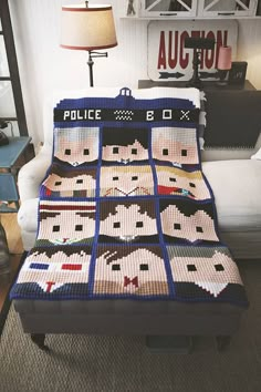 a police quilt on a couch in a living room with a lamp and chair behind it