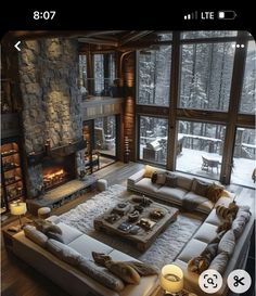 a living room filled with lots of furniture and a fire place in front of a large window