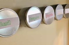 four round labels are attached to the side of a wall with magnets on it