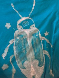 a blue t - shirt with a bug drawn on it