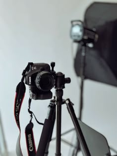 a camera and tripod sitting in front of a white wall