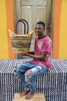 a man sitting on a bench holding a basket