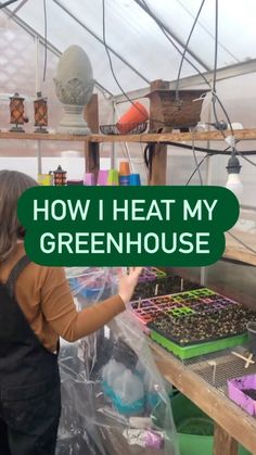 a woman in a greenhouse holding up a sign that says how i heat my greenhouse