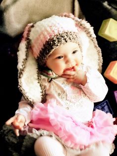 a baby girl wearing a knitted bunny hat